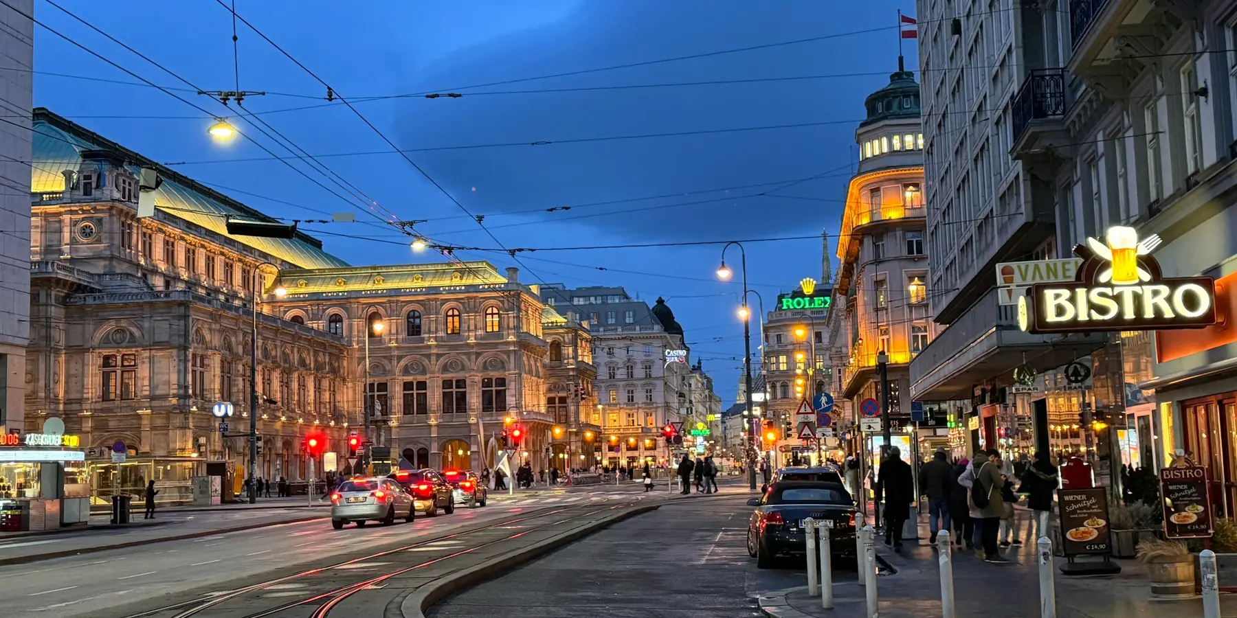 Straßenzug in Wien am Abend, Lokale im Erdgeschoß, Straßenbahnschienen (Symbolfoto)